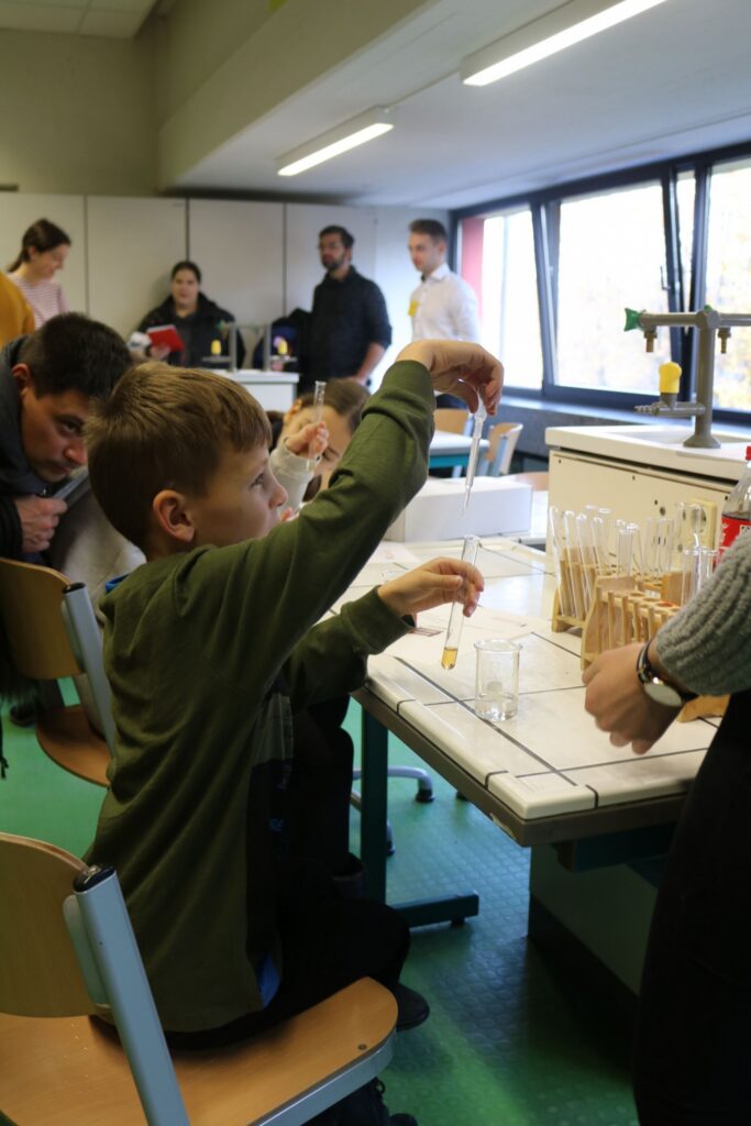 Schüler arbeitet im Chemielabor mit Reagenzgläsern.