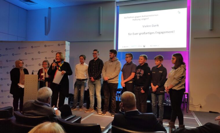 Schülergruppe steht auf der Bühne bei einer Veranstaltung.