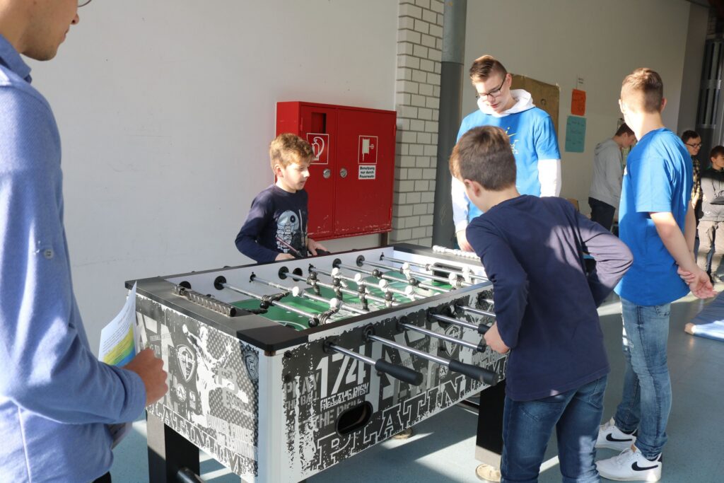 Schüler spielen Tischfußball in einer Schule.