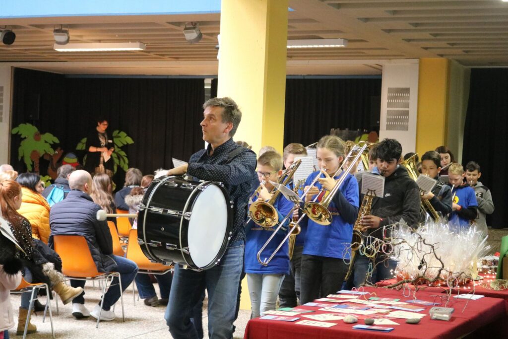 Musikgruppe zieht durch den Raum, Zuschauer sitzen an Tischen.