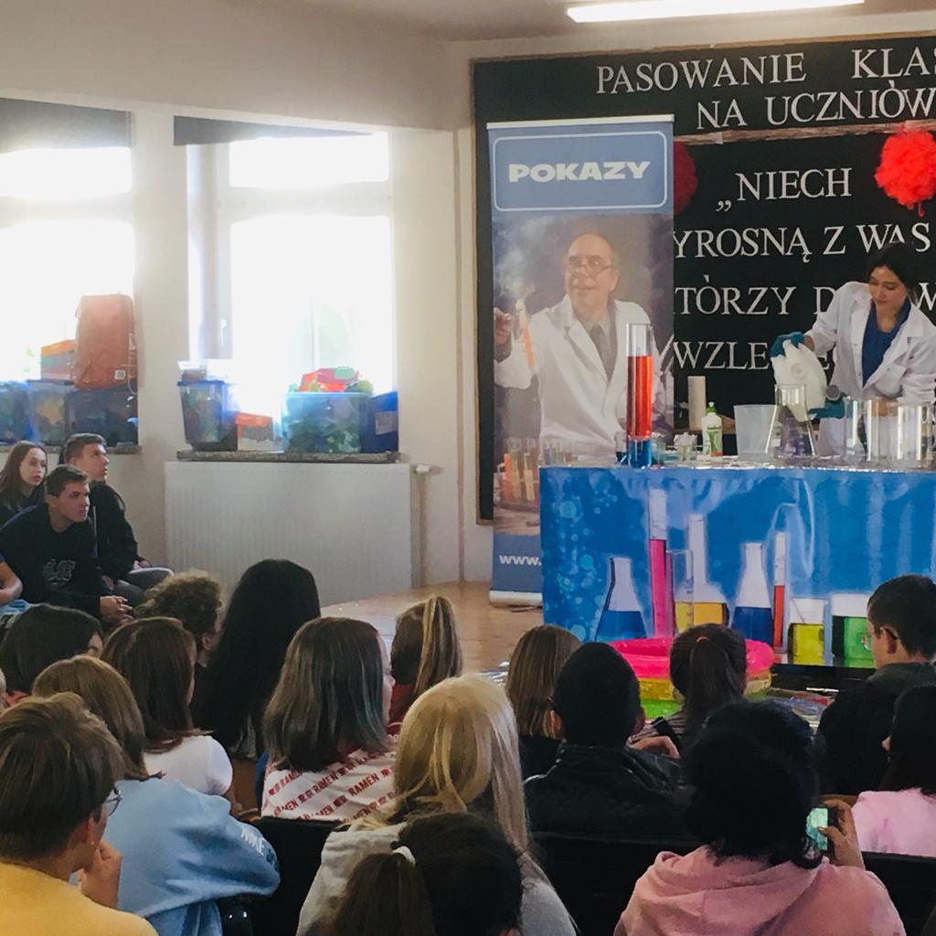 Chemievorführung mit Experimenten vor Schülern in einem Klassenraum.