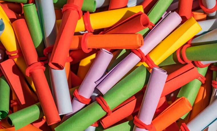 Bunte, gerollte Papierstreifen in verschiedenen Farben liegen übereinander.