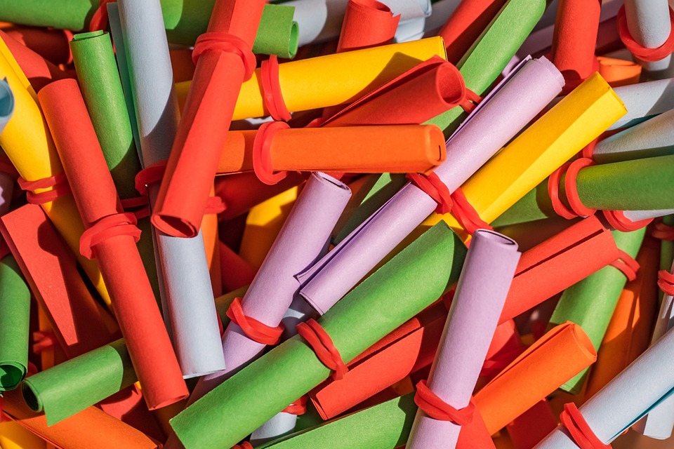 Bunte, gerollte Papierstreifen in verschiedenen Farben liegen übereinander.