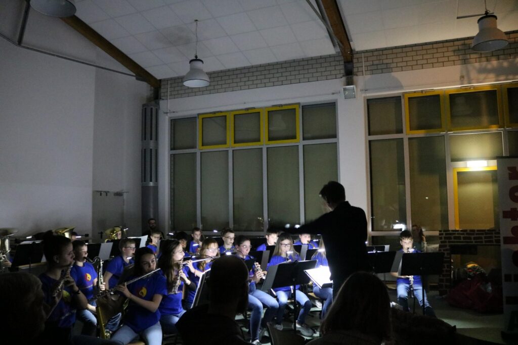Proben einer Schulband mit Lichtakzenten und konzentrierten Musikern.