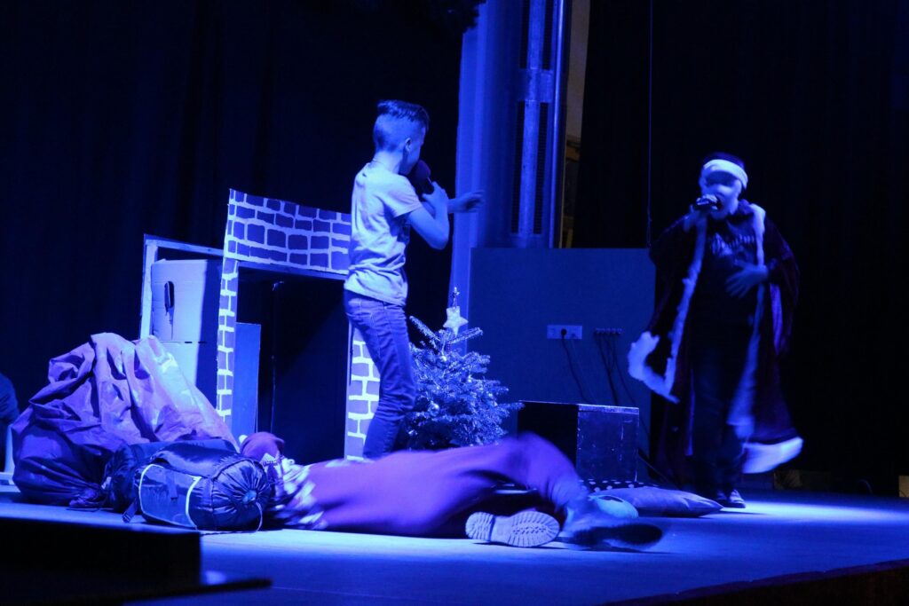 Schüler führen auf der Bühne eine Theatervorstellung auf.