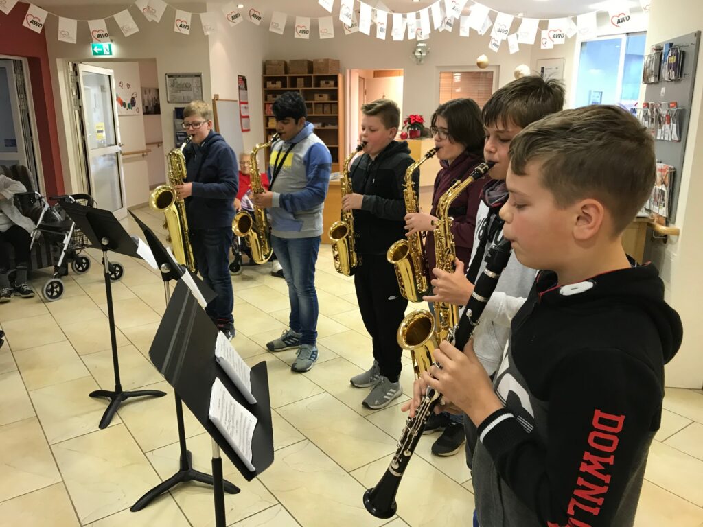 Sechs Schüler spielen in einer Reihe Saxophon und Klarinette.