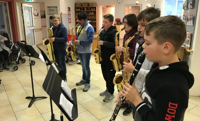 Sechs Schüler spielen in einer Reihe Saxophon und Klarinette.