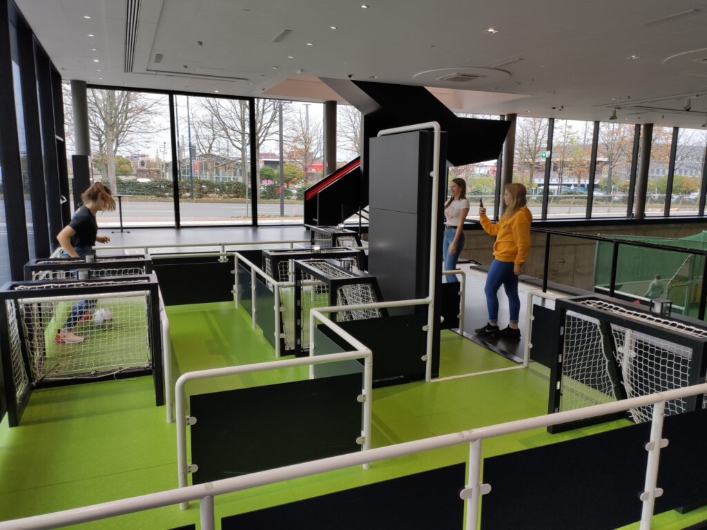 Kinder spielen in einer modernen Indoor-Spielanlage mit Fußballtoren.