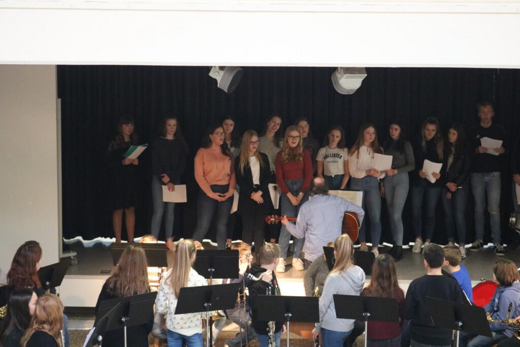 Schülerinnen und Schüler stehen auf der Bühne und präsentieren ein Programm.