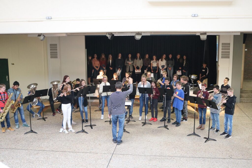 Schüler spielen in der Aula in einer Musikaufführung.