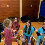 Schüler*innen sitzen in einem Raum und spielen Posaune.