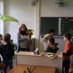 Schüler und Lehrerin mit einer Tuba in einem Klassenzimmer.