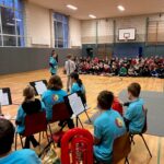 Schüler spielen in der Sporthalle, Publikum sitzt auf der Tribüne.