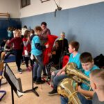 Schülerinnen und Schüler probieren Musikinstrumente im Musikraum.
