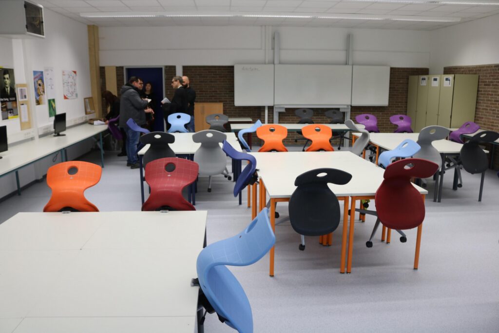 Moderne Classroom mit farbigen Stühlen und Tischen, Gruppenarbeiten stattfinden.