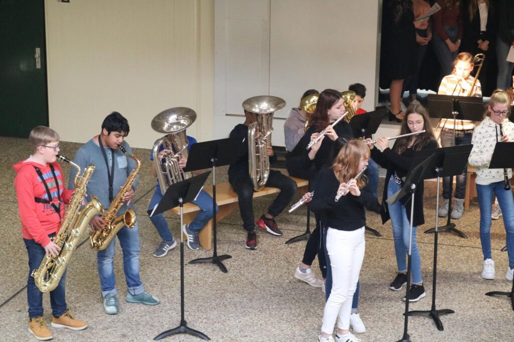 Schüler spielen in einer Gruppe Blasinstrumente und Flöte.