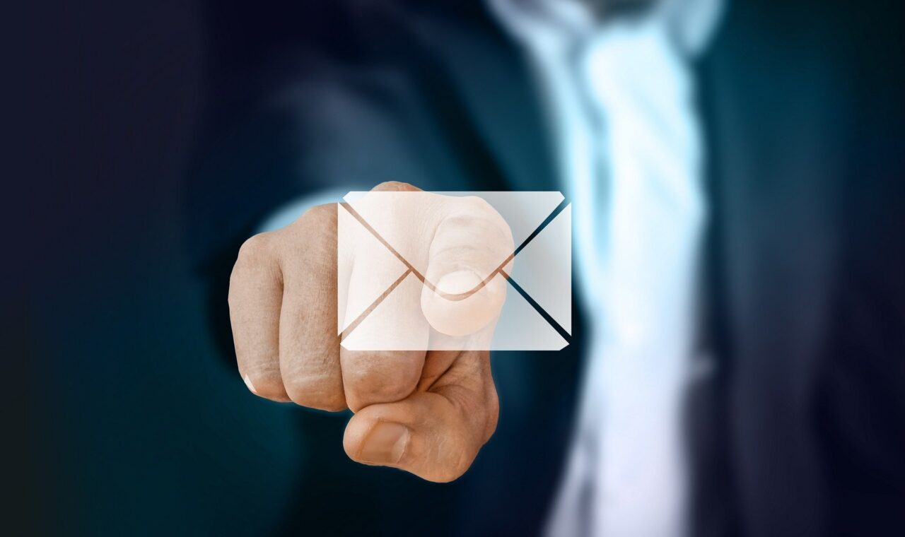 Hand zeigt auf ein digitales Umschlag-Symbol.