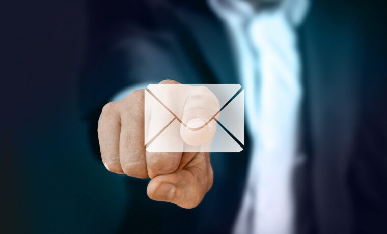 Hand zeigt auf ein digitales Umschlag-Symbol.