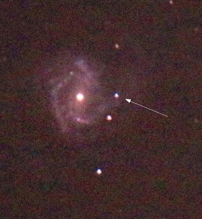 Supernova in einer Spiralgalaxie mit sichtbaren Sternen im Hintergrund.