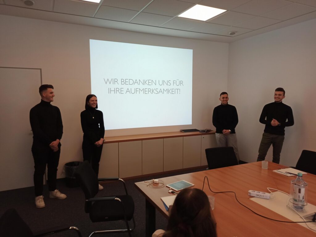Präsentation in einem Besprechungsraum mit vier Personen.