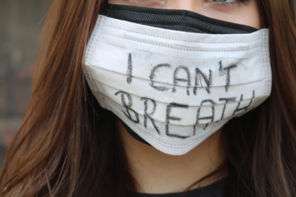 Eine Person trägt eine Maske mit der Aufschrift "I can't breathe".