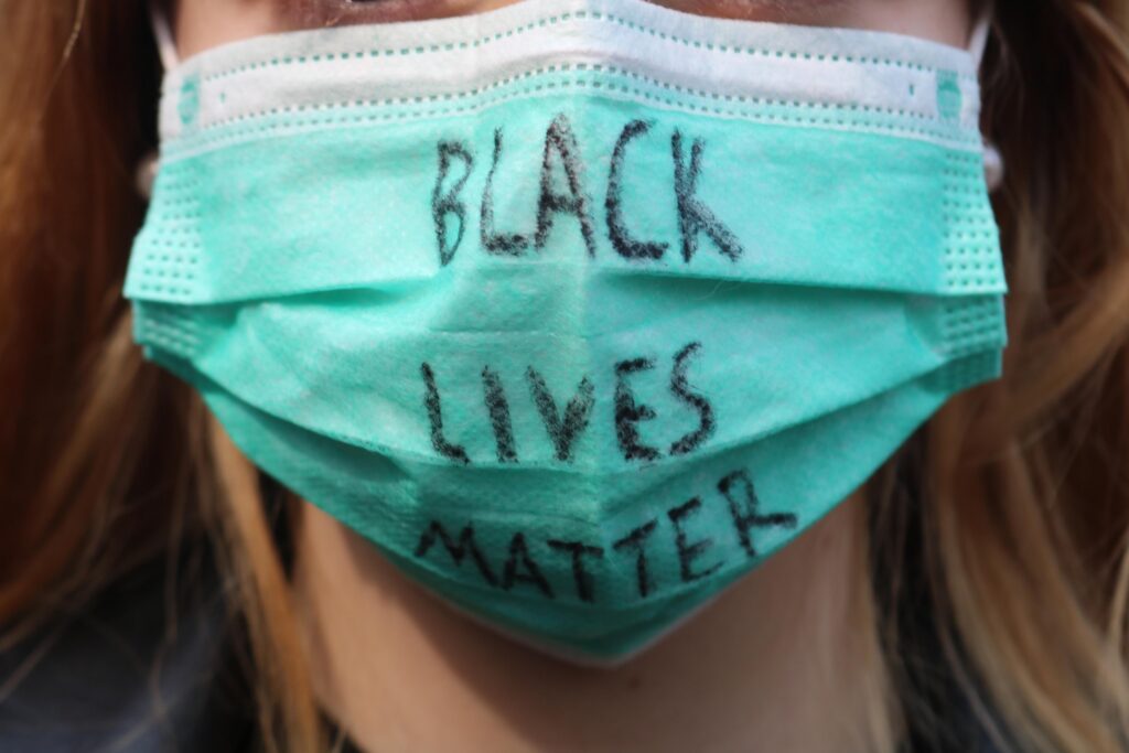 Mensch mit Maske, darauf steht "BLACK LIVES MATTER".