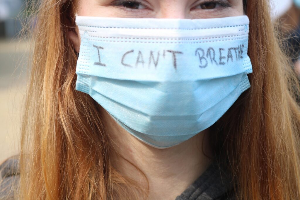 Mädchen trägt eine Maske mit der Aufschrift "I CAN'T BREATHE".