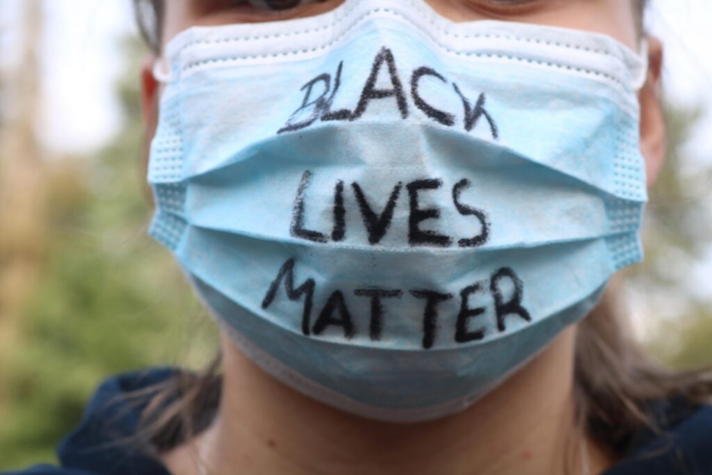 Mensch trägt eine Maske mit der Aufschrift "BLACK LIVES MATTER".
