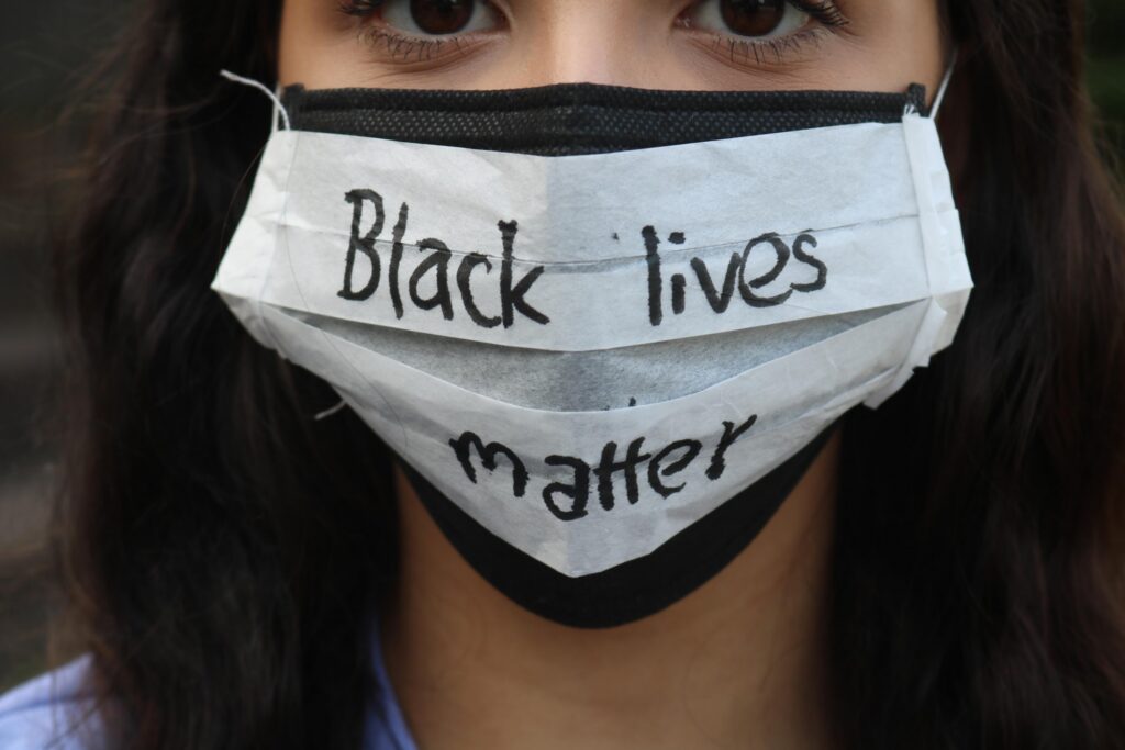 Person trägt einen Mundschutz mit der Aufschrift "Black lives matter".