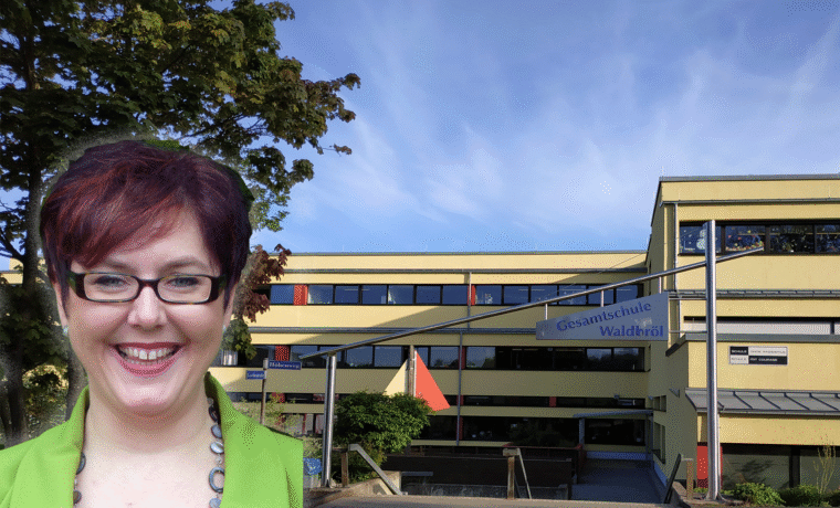 Schulgebäude mit einem lachenden Lehrer im Vordergrund.