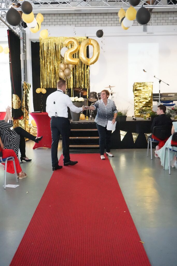 Ein festlich dekorierter Raum mit rotem Teppich und Dekoration in Schwarz und Gold.