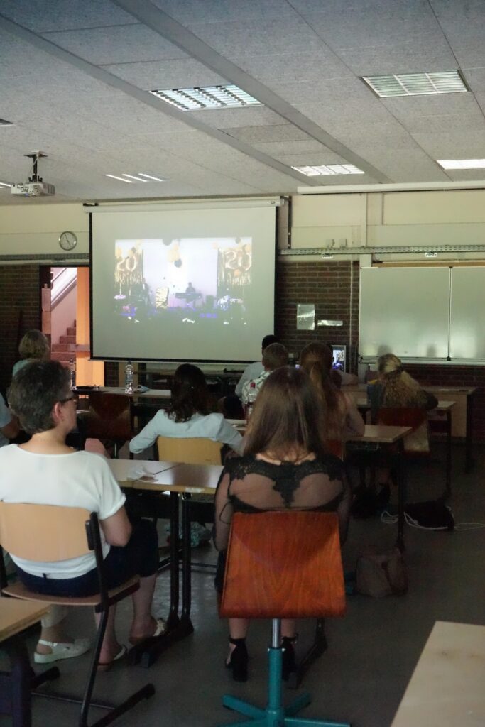 Schüler sitzen in einem Klassenraum und schauen eine Präsentation.