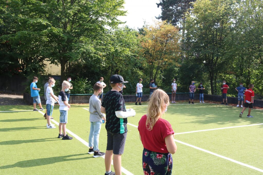 Gruppentraining auf einem Sportplatz mit Kindern und Jugendlichen.