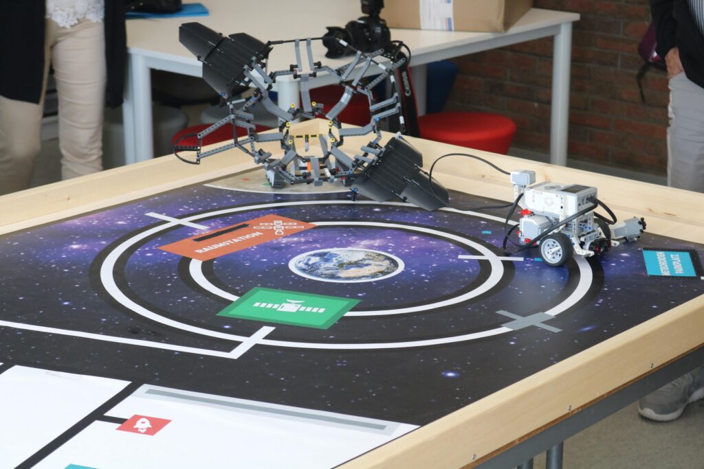 Roboter und Sensoren auf einer Tischoberfläche mit einem Weltraum-Thema.