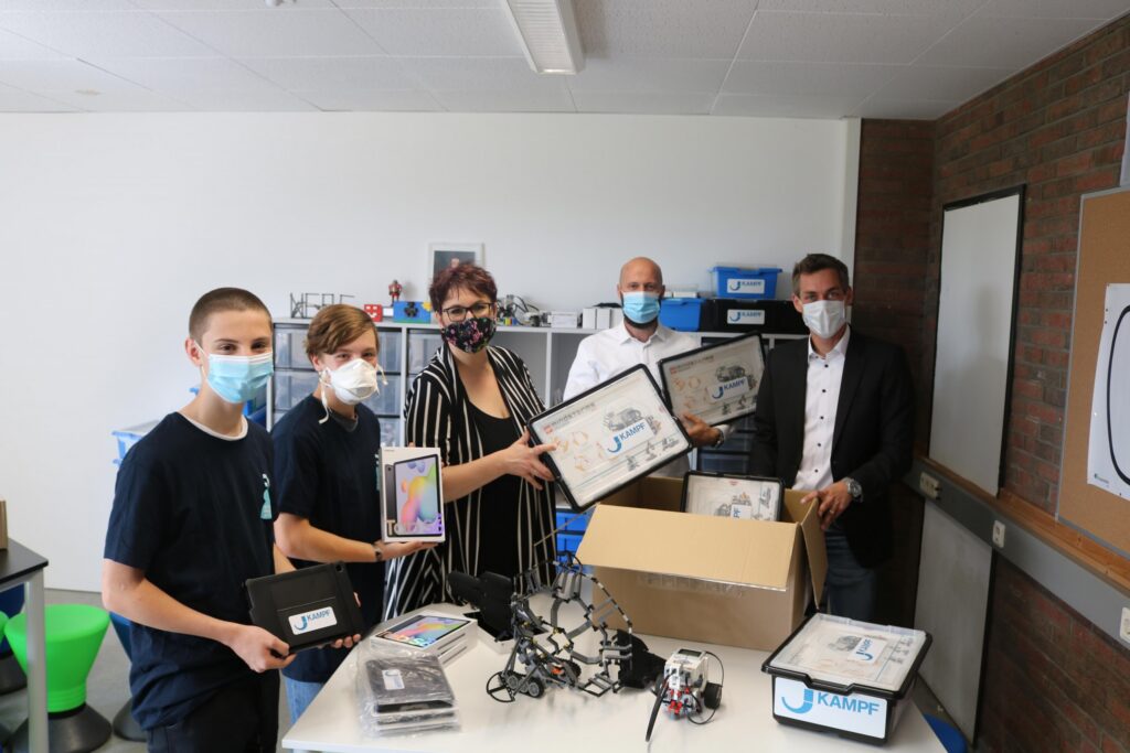 Schüler und Lehrer präsentieren Technikmaterialien in einem Klassenraum.