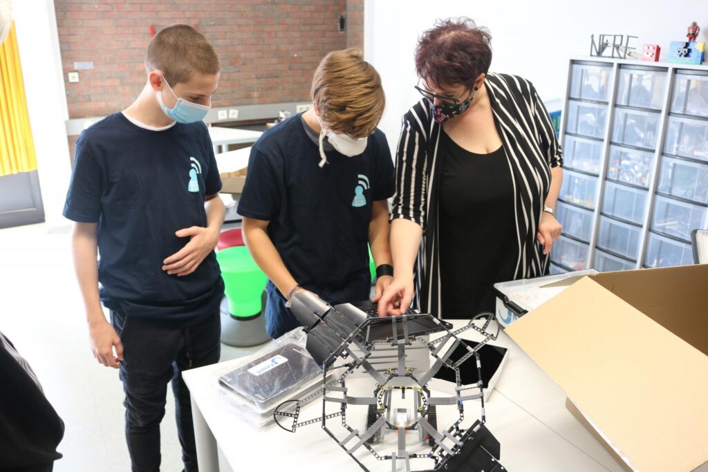 Schüler und Lehrerin arbeiten gemeinsam an einem technischen Projekt.