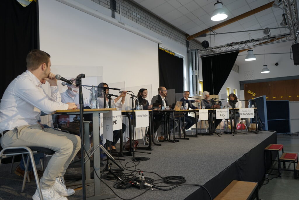 Podium mit mehreren Sprechern bei einer Veranstaltung in der Schule.