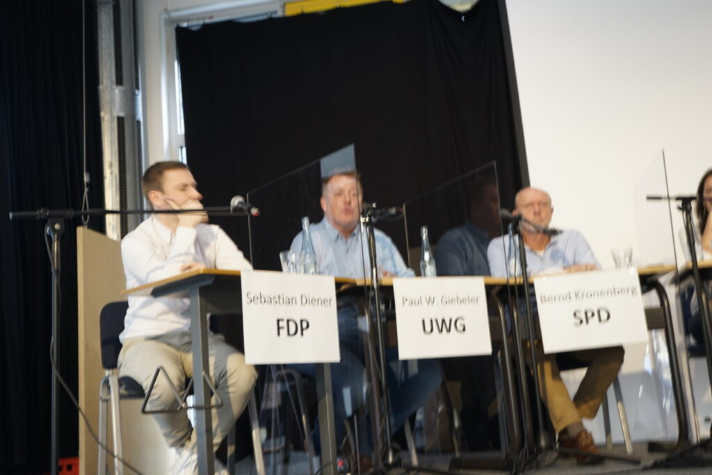 Podiumsdiskussion mit Vertretern der FDP, UWG und SPD.