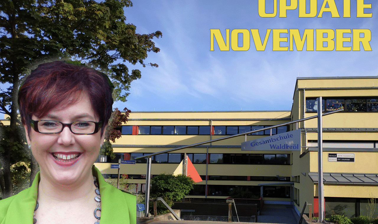 Frau mit Brille vor dem Schulgebäude, Monatsupdate im November.