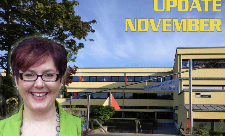 Frau mit Brille vor dem Schulgebäude, Monatsupdate im November.