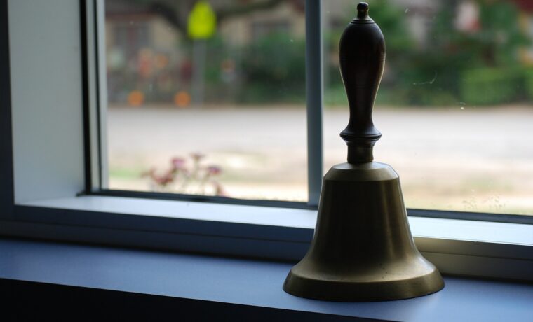 Eine goldene Glocke steht auf einer Fensterbank.