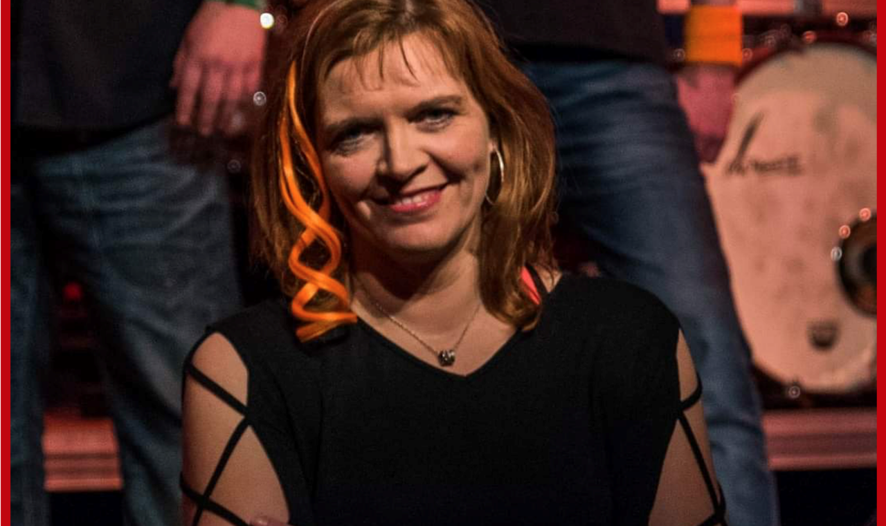 Frau mit lächelndem Gesicht, mehrere Personen im Hintergrund. Logo der Gesamtschule Waldbröl.