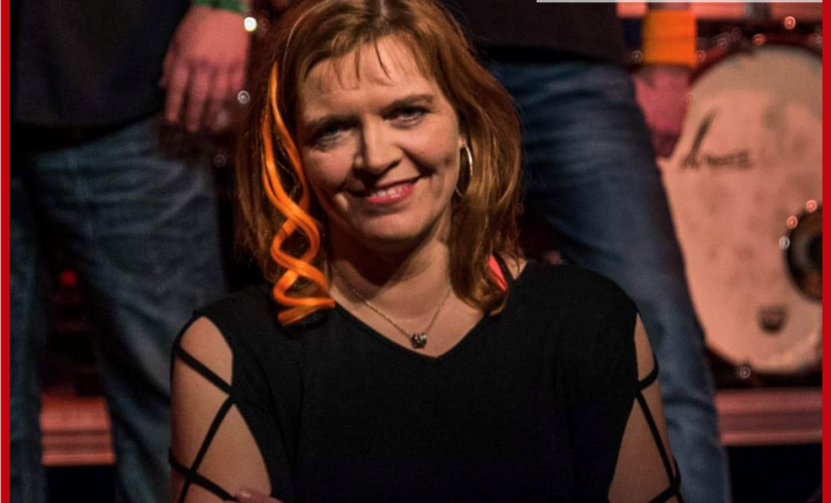 Frau mit lächelndem Gesicht, mehrere Personen im Hintergrund. Logo der Gesamtschule Waldbröl.