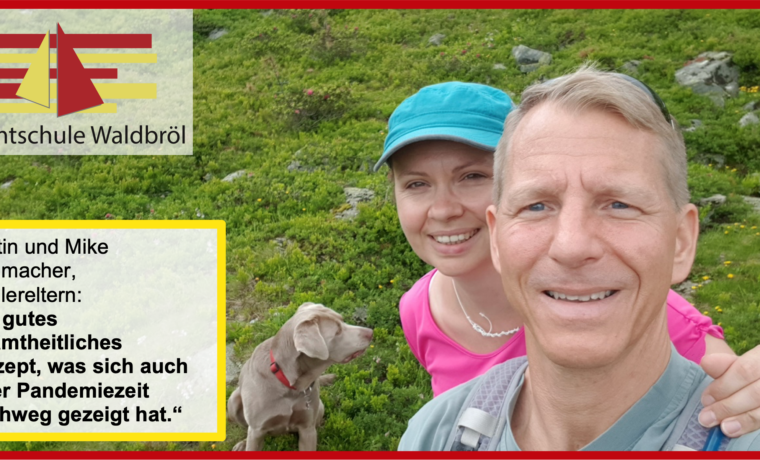 Kerstin und Mike Schumacher stehen im Freien mit einem Hund auf grüner Wiese.