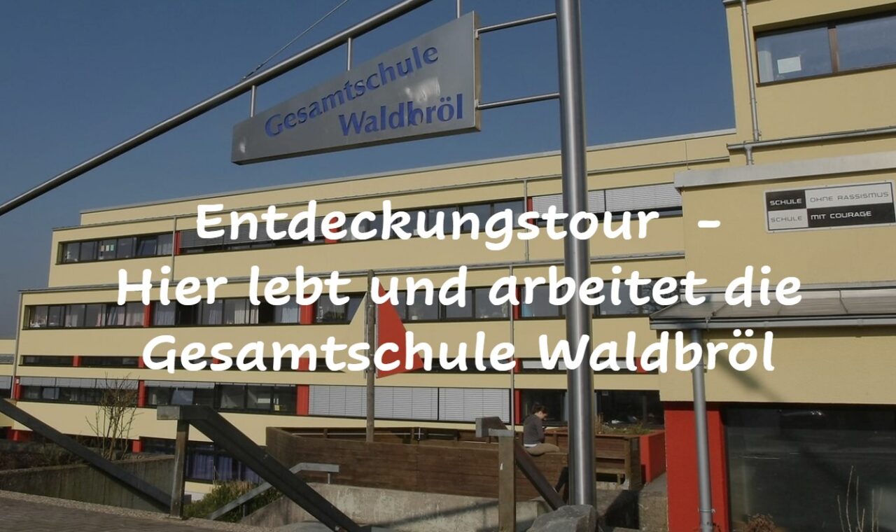 Das Bild zeigt das Gebäude der Gesamtschule Waldbröl mit einem Schild zur Entdeckungstour.