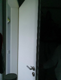 Offene Tür in einem dunklen Raum.