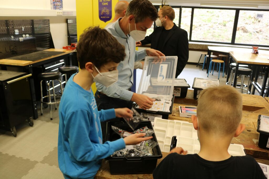 Schüler arbeiten an einem Projekt mit Materialien in einem Klassenraum.