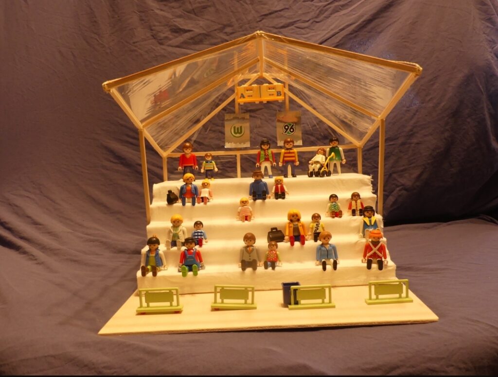 Modell einer Zuschauertribüne mit Playmobilfiguren und Sitzplätzen.
