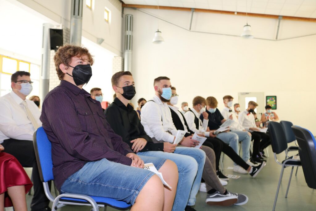 Schüler sitzen in einem Raum und tragen Schutzmasken.