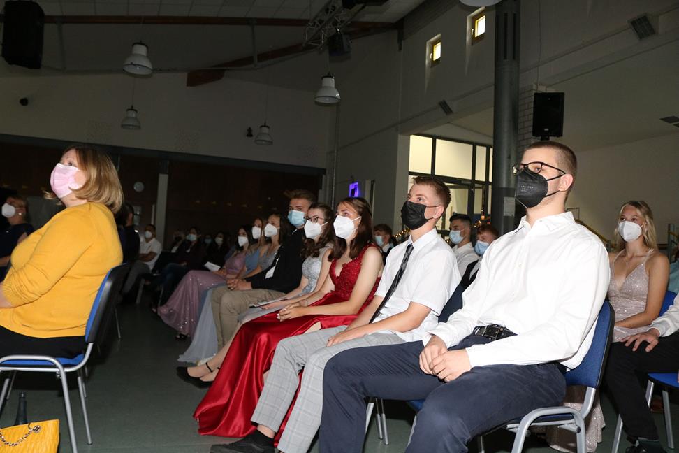 Eine Gruppe von Schülern sitzt in einem Raum, alle tragen Masken.